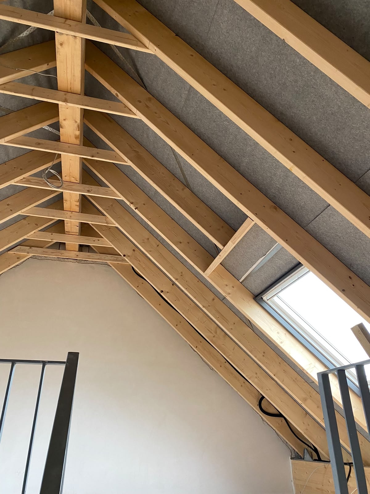 Dachstuhl mit Dachfenster und Holzbalken