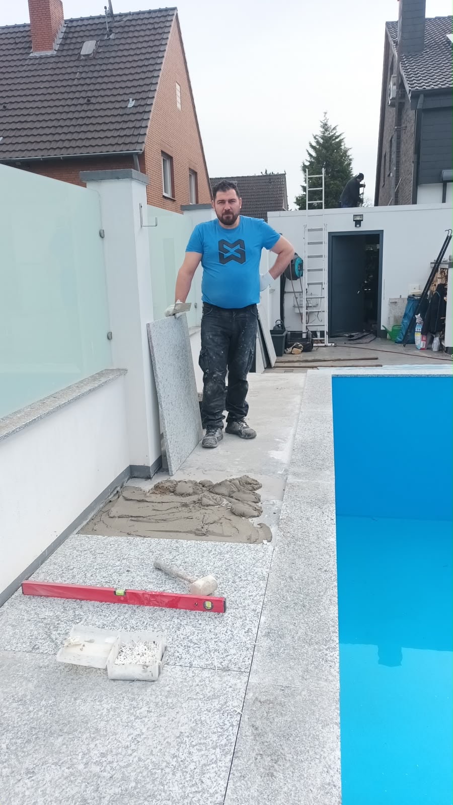 Mitarbeiter beim Verlegen der Poolumrandung